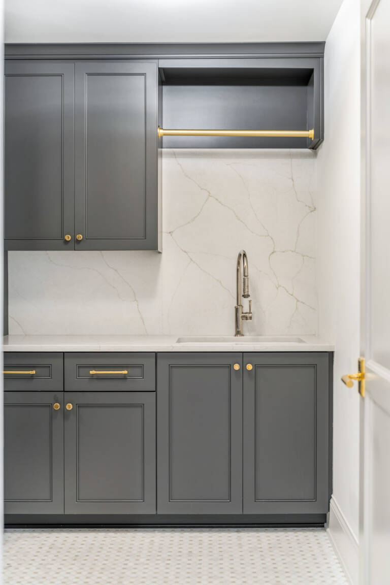 Luxury laundry room with grey cabinets.