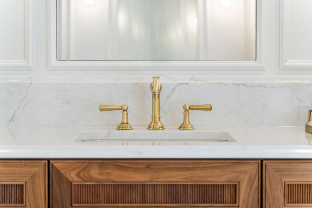 Primary bathroom wooden vanity with brass hardware