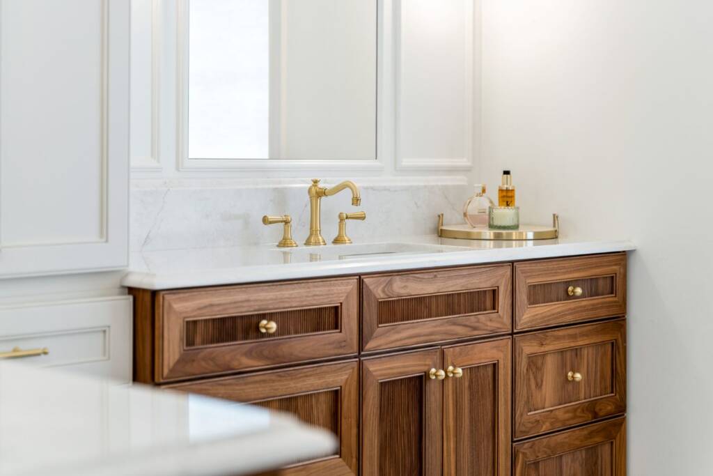 Primary bathroom wooden vanity with brass hardware