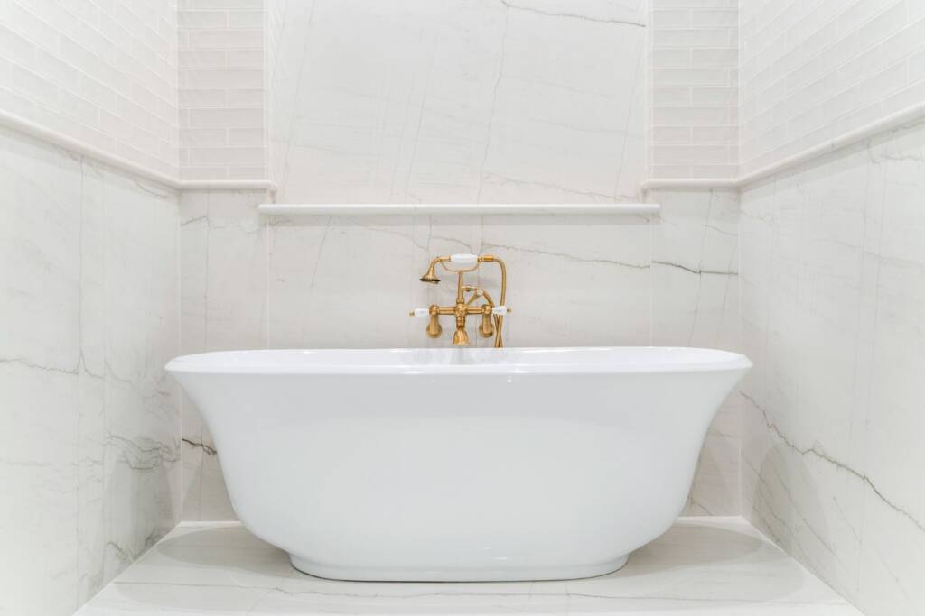 Primary bathroom bath tub closeup with brass hardware